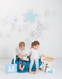 可爱的小孩坐在蓝色编织的蓝毛小孩子旁边图片