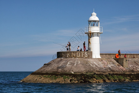 人们在布里克瑟姆港的灯塔附近钓鱼图片