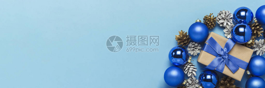 蓝色背景上带有蓝丝带圣诞树装饰球和白色和金色松果的礼品盒圣诞快乐和的概念极简主义平躺高清图片下载-正版图片503088154-摄图网