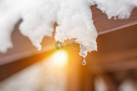 屋顶上融化的雪冰柱的特写镜头落水滴春天的开始满足冷热概念新鲜的图片