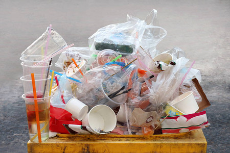 垃圾倾倒塑料垃圾垃圾塑料垃圾瓶和袋泡沫托盘堆在垃圾箱黄色图片