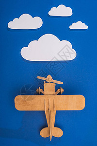 蓝色天空中木制玩具飞机的顶部视图上图片