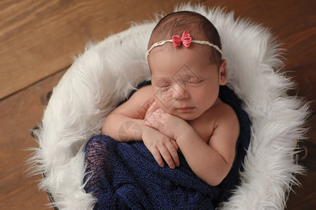 11天大的新生女婴睡在一个小的毛皮衬底桶里图片