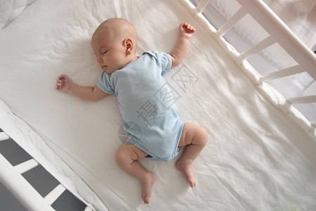 顶视图广角睡觉的新生婴儿躺在婴儿床里图片