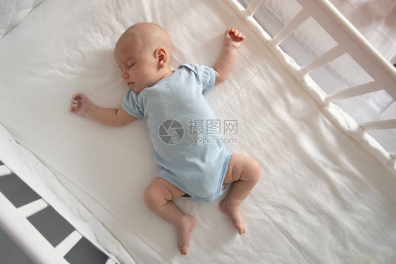 顶视图广角睡觉的新生婴儿躺在婴儿床里图片