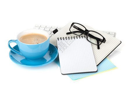 蓝咖啡杯眼镜和办公室用品白图片