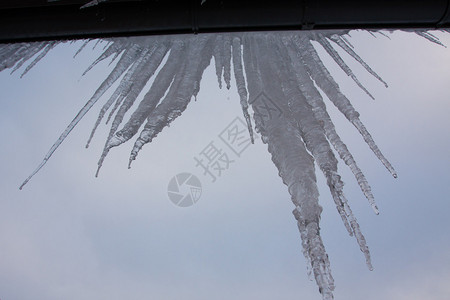 屋顶上的冰棍在天空背景的冬天背景图片