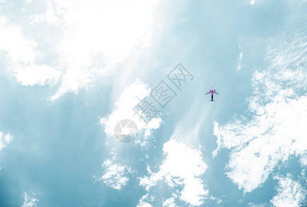 飞机在蓝天白云中飞行的底视图图片