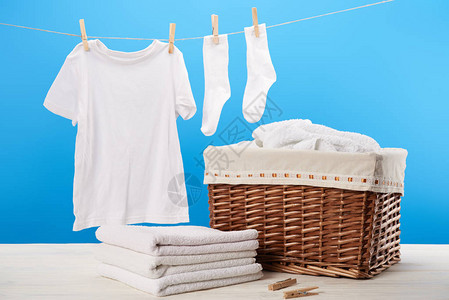 洗衣篮一堆干净的软毛巾和白衣挂图片