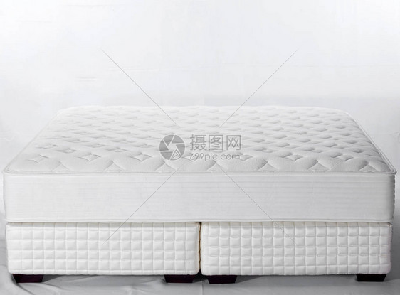 浅色房间内白色和灰色床垫的特写图片