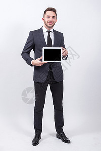 穿着经典灰色西装和领带的白色背景微笑成功的年轻学生图片