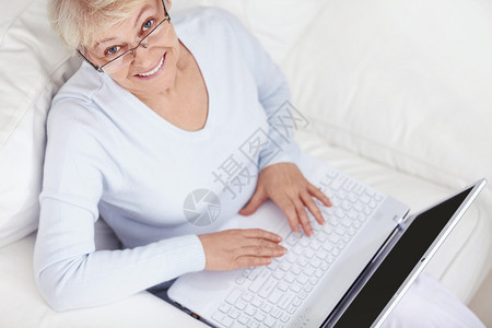 一位有吸引力的中年妇女在白色沙发上架背景图片
