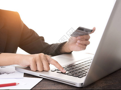 使用电脑笔记本电脑持有信用卡的商人手掌图片