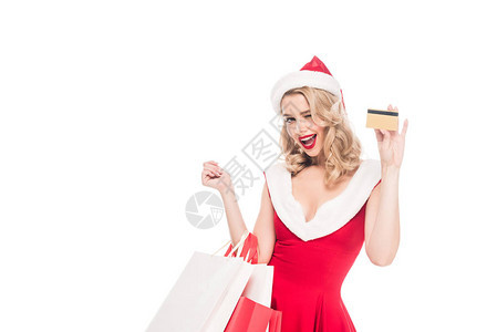 穿着圣诞节礼服的快乐的圣塔女孩拿着购物袋图片