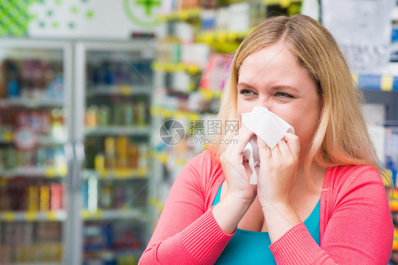 一个喷嚏的年轻女子有烟道进入化学家的图片