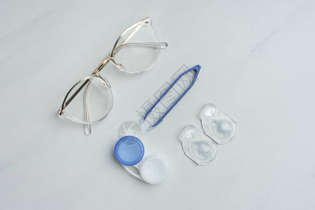 白色表面装有眼镜隐形眼镜容器和织字器图片