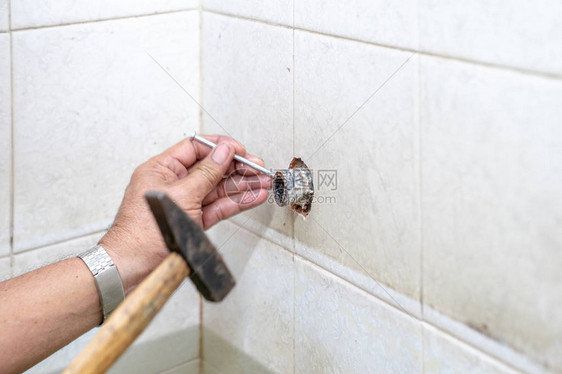 亚洲男人试图修补旧洗手间里图片