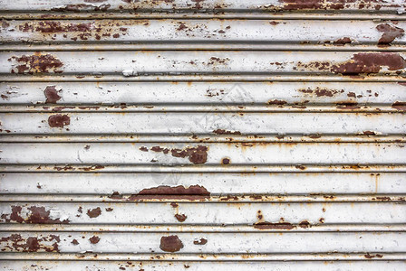 旧的被损坏的白色滚动钢门一个完全生锈的百叶图片
