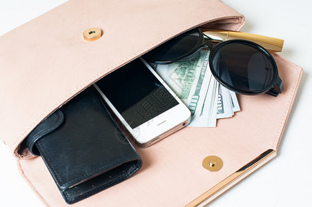 化妆品太阳镜钱包和智能手机在一个开放的米色女人的离合器手提图片
