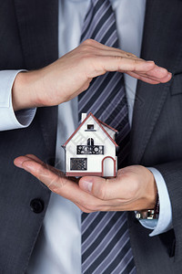 商人持有房屋模型保护手势财产保险和安保概念图片