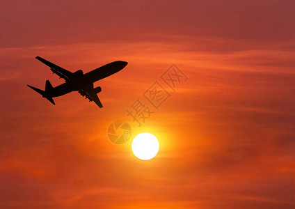 日落时剪影客机飞向太阳上方的高空图片