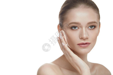 美容化妆品年轻漂亮的女人的肖像与粉垫扑在脸上应用化妆粉特写年轻女模特图片