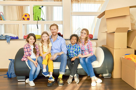 幸福的家庭坐在沙发上微笑着的人和纸板盒改图片