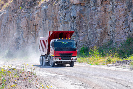 一辆倾卸卡车在采石场露天矿坑开采花岗岩图片