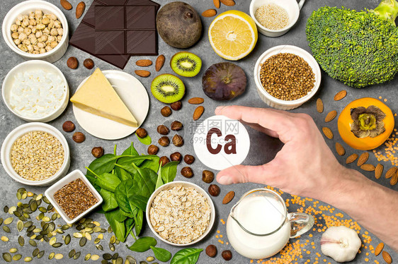 富含钙的食物各种维生素和微量营养素的天然来源有益于健康和均衡饮食的物预防维生素缺乏症男人的手拿着带有图片