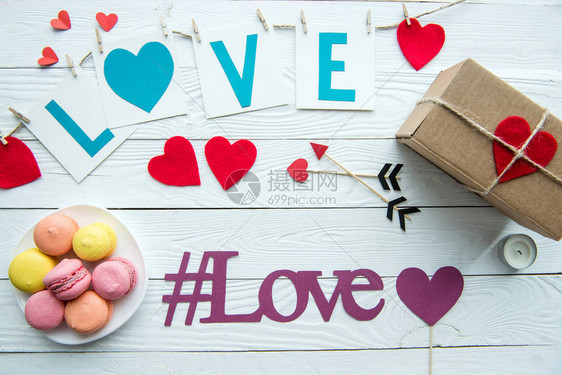 情人节装饰马卡龙饼干礼品盒和爱情牌在木桌图片