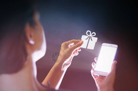 一个女人手里拿着智能手机的形象她得到一份礼物数字技术时图片