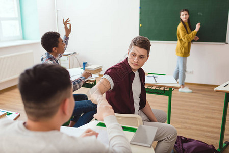 多元文化高中学生在课堂上打拳头和同学后图片