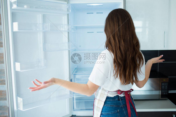 隔离期间厨房里的年轻女子看上面没有的空冰箱架子饿了不会做饭女人的背影不图片