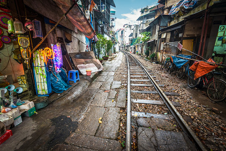 越南河内有房屋的狭窄街道上运行的铁路透视图运输问题的非同寻常的解决方案人们的危险街区图片