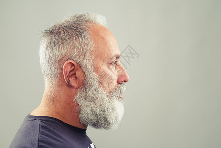 长胡子老人在灰色背景和空复写图片