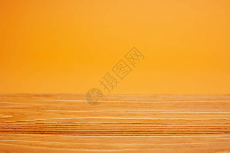 空的木质表面和明亮的橙色背景图片