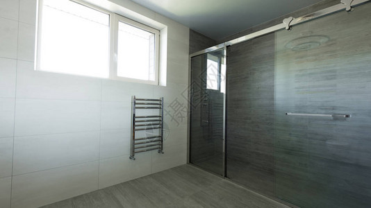 带灰色玻璃淋浴间的空浴室内部图片