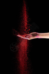 黑色背景红辣椒粉的成年妇图片