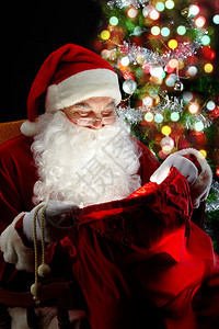 圣诞老人坐在圣诞树上看图片