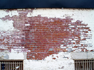 邋遢风化的砖墙和带栅栏的窗户图片