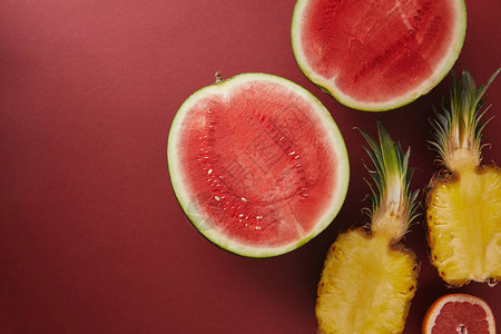 红色表面切西瓜和菠萝的顶视图图片