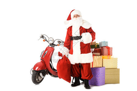 圣诞老人站在老式红色摩托车麻袋和礼品盒图片