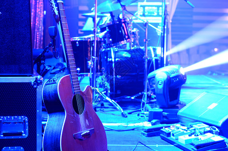 音乐会前舞台上的原声吉他架子鼓扬声器和其他音乐设备霓虹灯概念图夜总会图片