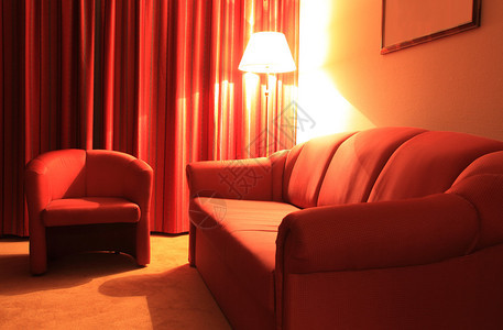 带有红色沙发手椅和地板灯的室内图片