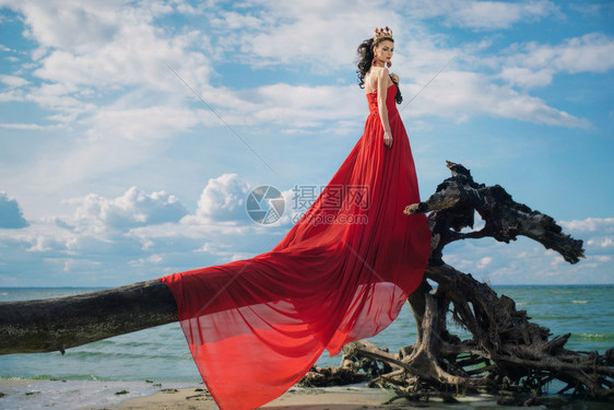 浪漫的女人站在树上水上面的树木上穿着图片