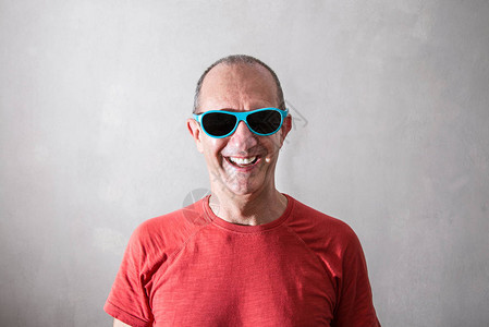 一个戴蓝眼镜的微笑男人背景图片