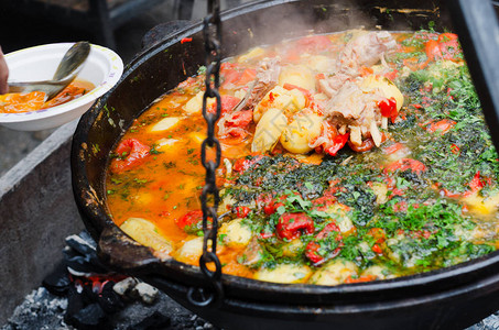 火锅底料蔬菜和炖肉一起煮在锅炉里街边背景