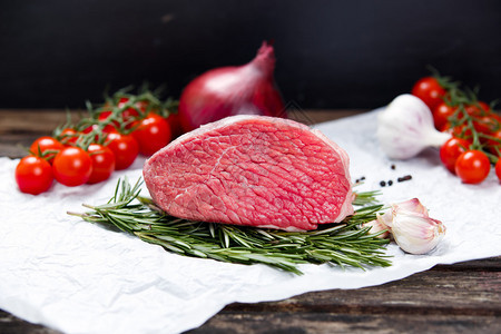 一块新鲜的肉牛肉板装饰着绿背景图片