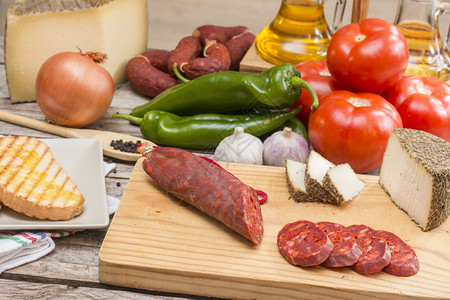 餐桌上的不同西班牙健康食品香肠奶酪西红柿胡椒大蒜图片