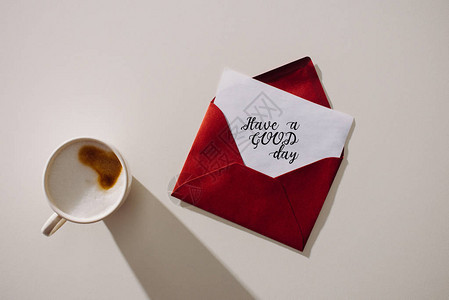 红色信封的顶部视图在纸和咖啡杯上有一背景图片